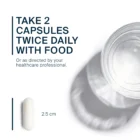 Text on image reads: Take 2 Taurine 1000 mg capsules twice daily with food or as advised by your healthcare professional. Each vegcap contains taurine. Image shows a white 2.5 cm capsule and a glass of water casting a shadow.