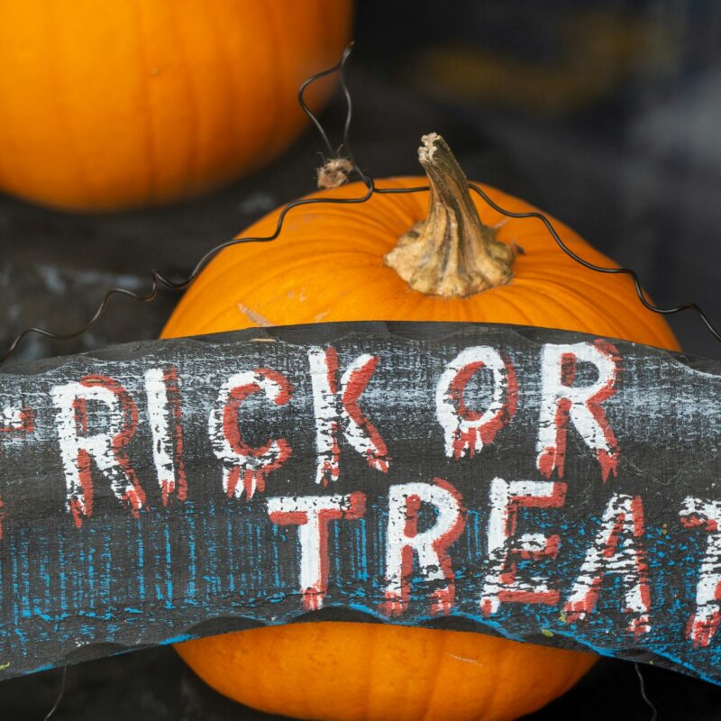 pumpkin with trick or treat sign in front