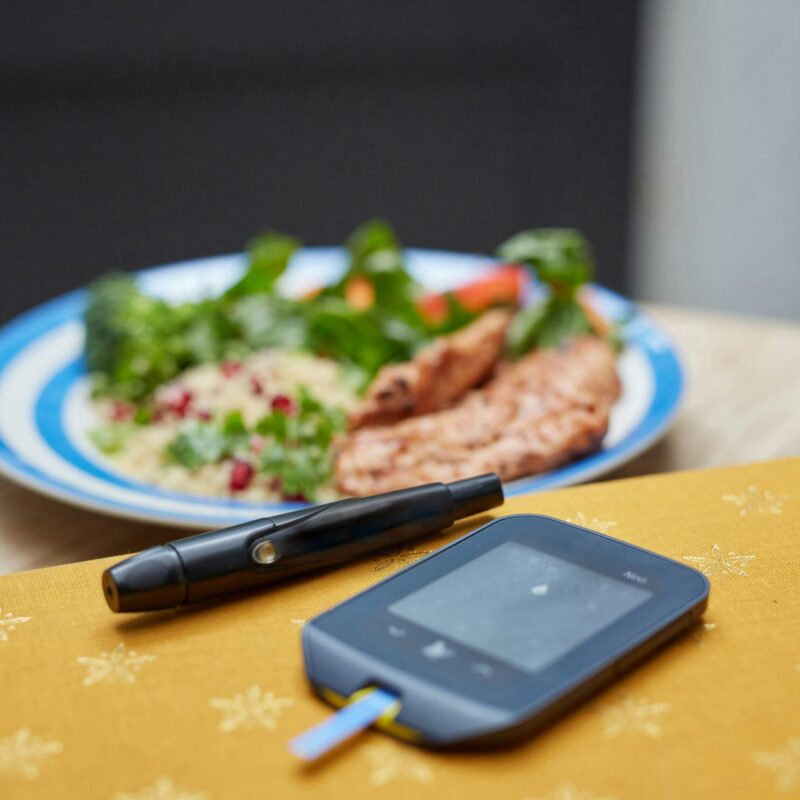 Glucose monitor with healthy meal in background