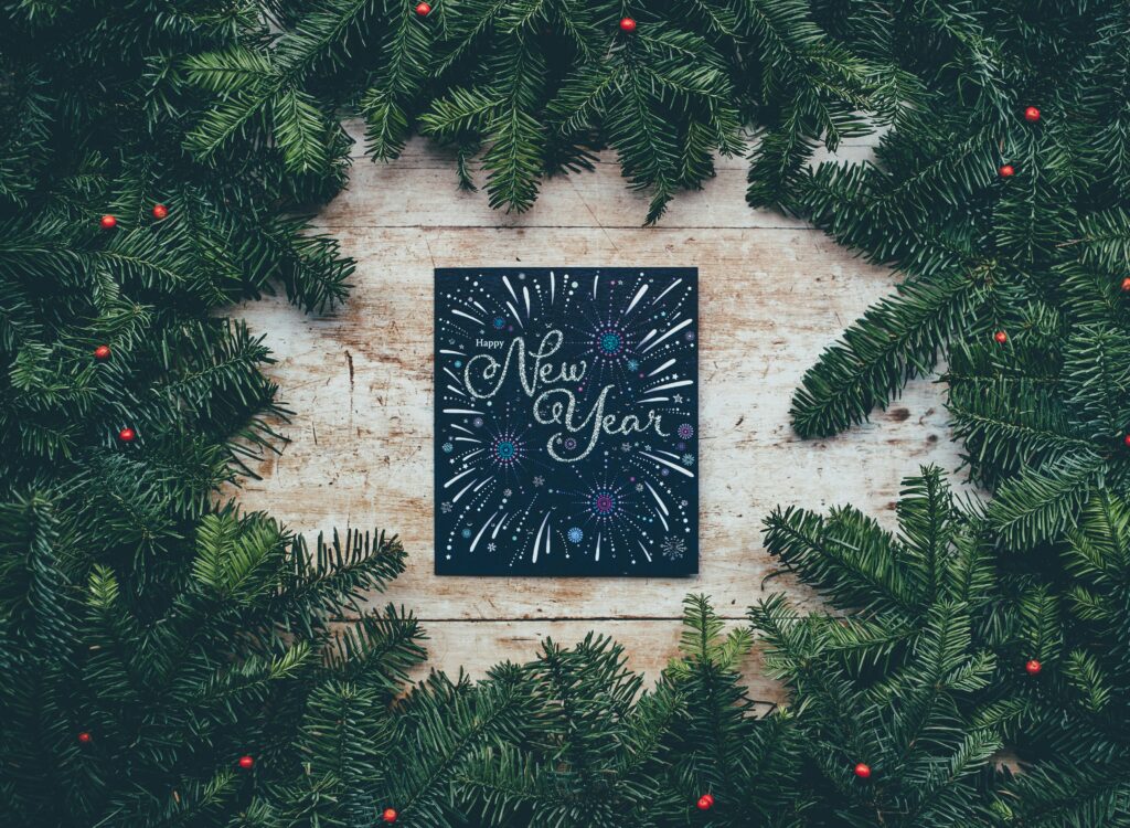 happy new year sign with pine wreath surrounding it