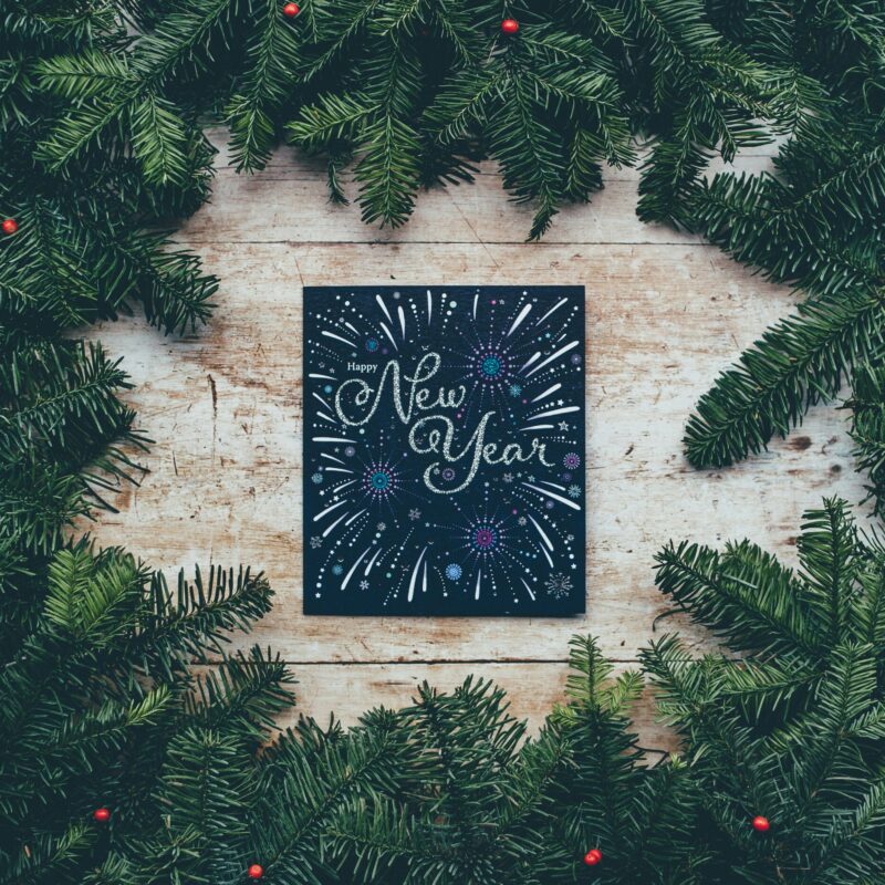 happy new year sign with pine wreath surrounding it