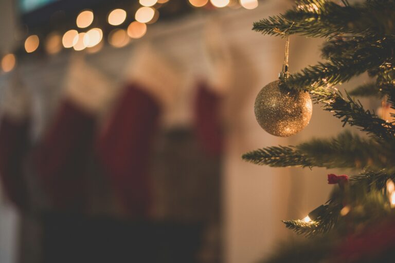 up close on a Christmas tree with stockings hanging in the background