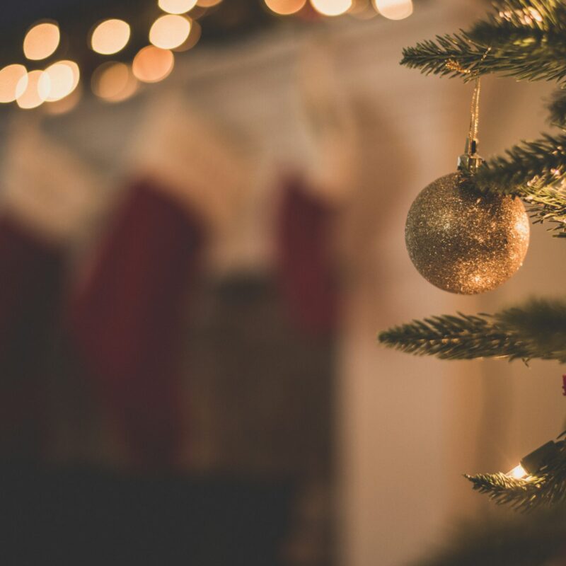 up close on a Christmas tree with stockings hanging in the background