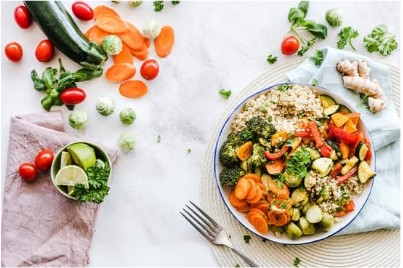 plate of healthy food with vegetables in background