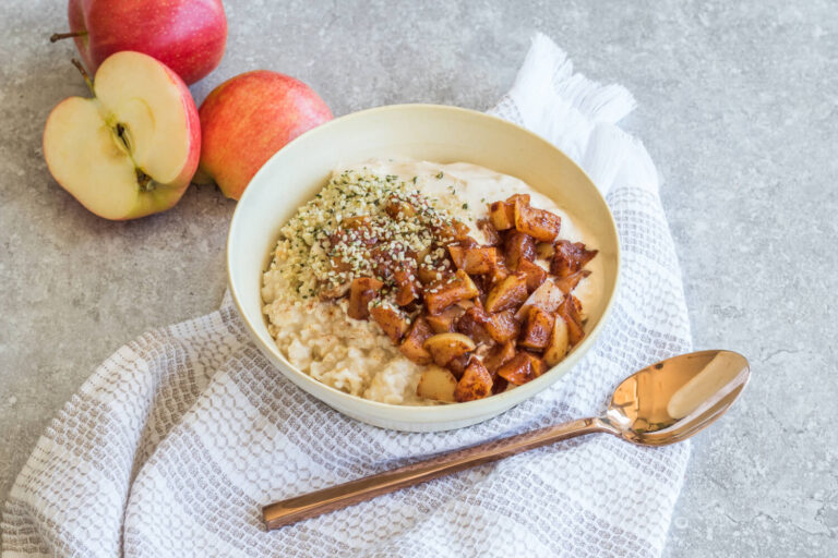 Creamy apple pie, high protein, high fiber oatmeal in a white bowl on a table.