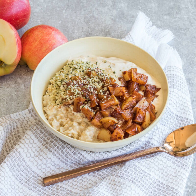 Creamy apple pie, high protein, high fiber oatmeal in a white bowl on a table.