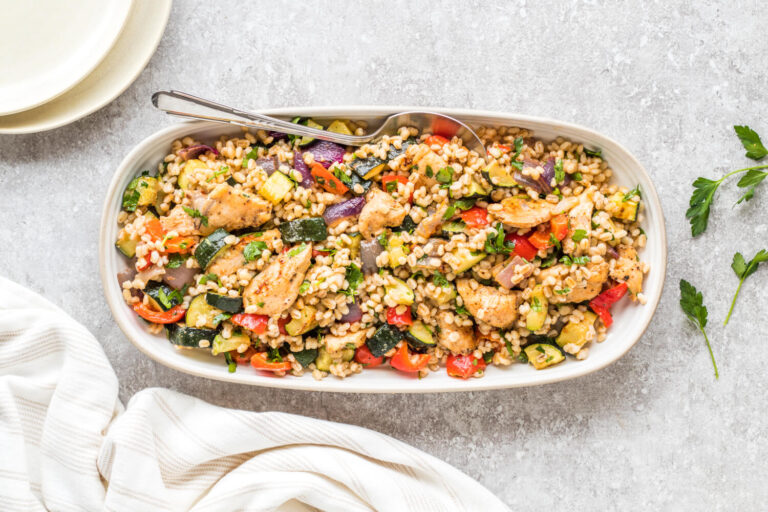 Harissa Chicken, Barley & Roasted Veggies in a serving tray on a table