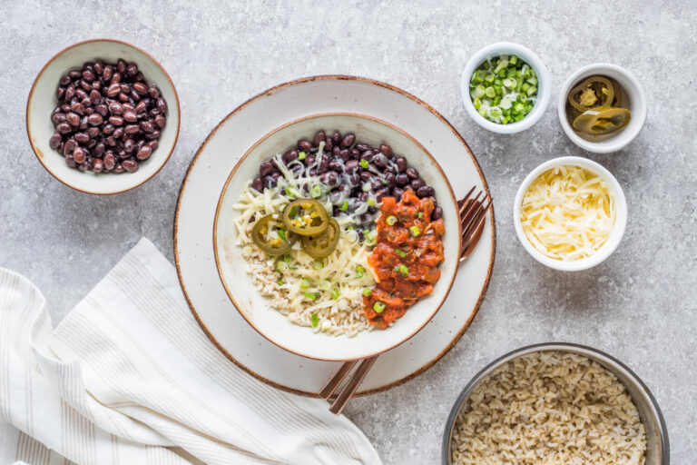 burrito bowl with toppings on the side on a table