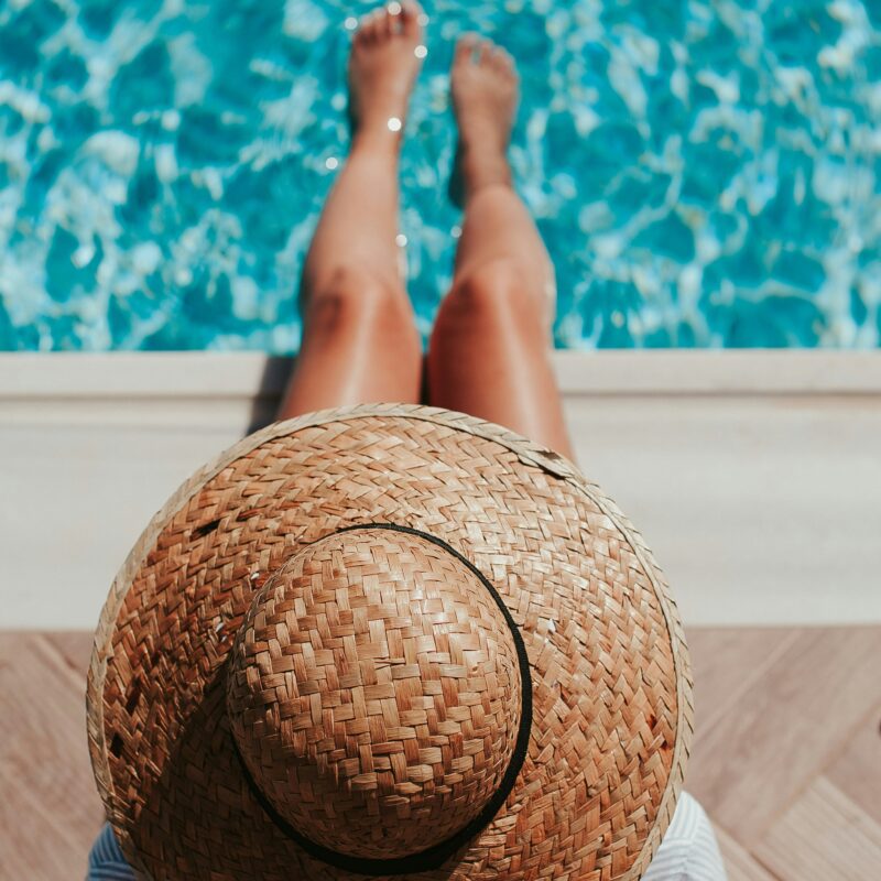woman sitting on edge of pool in the sun