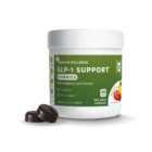 A white container labeled GLP-1 Support Gummies Supplement is shown with a green label featuring icons and text. Two dark, round gummies sit beside the container.